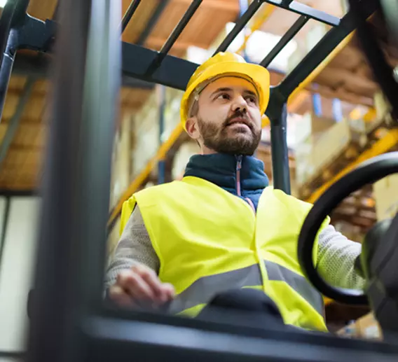 Man on forklift works to transload a shipment