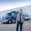 Female dedicated driver standing beside an ArcBest truck.